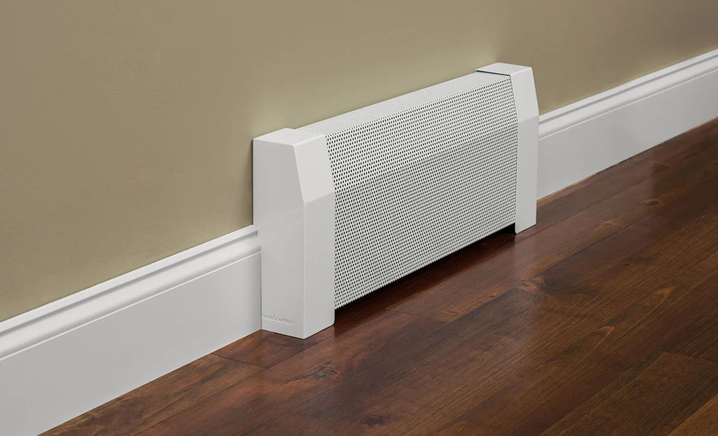 Tall baseboard heater cover in white against a beige wall and dark wood floor.