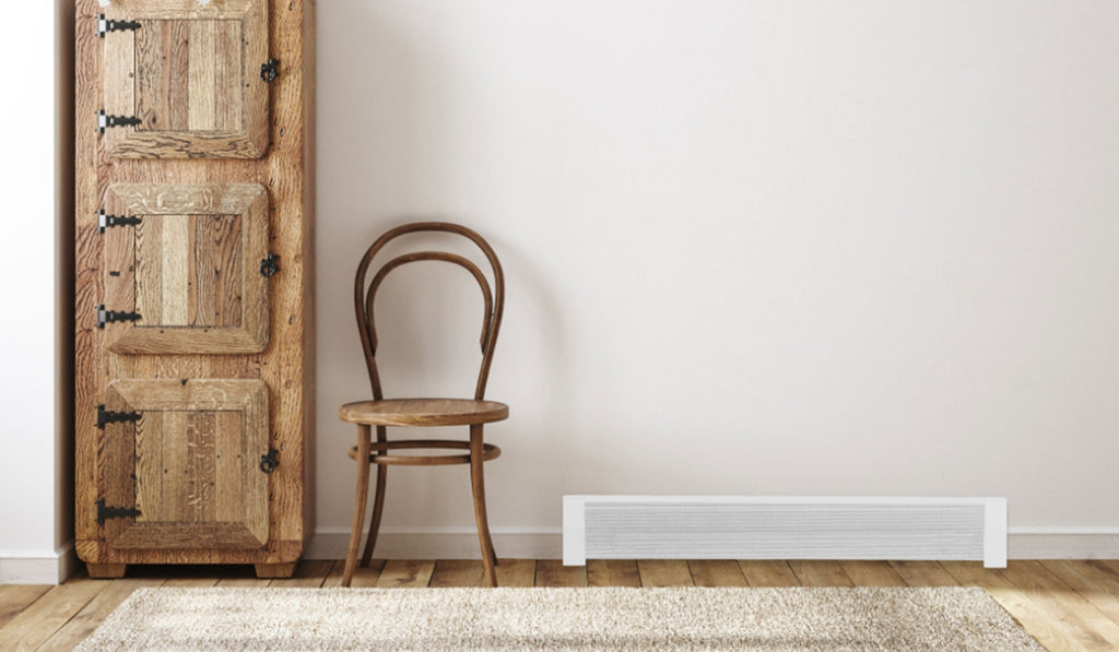 Small room with white walls and white baseboard heater and light wood chair and wardrobe.