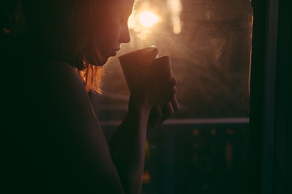 woman drinking coffee at sunrise