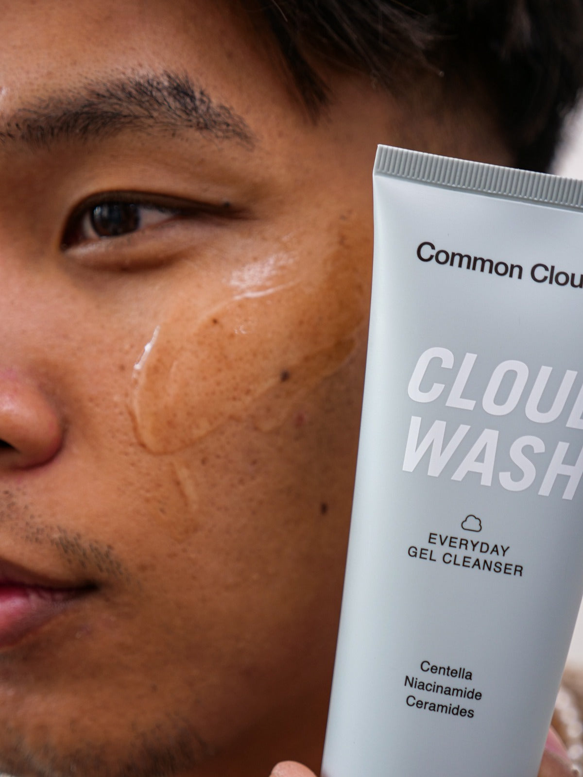 Person som håller fram Cloud Wash, en ansiktsrengöring som skonsamt rengör huden och har ingredienser som centella, niacinamide och ceramider