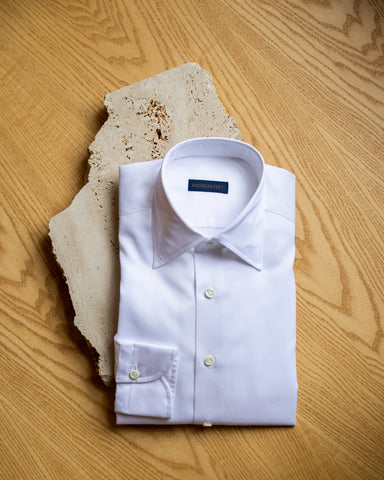 Folded white shirt on table.