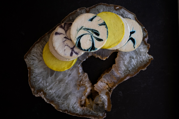 Cheese wheels on top of crystal board seen from above