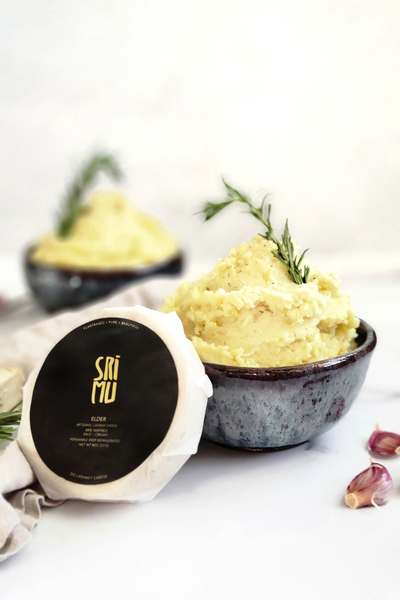 Roasted Garlic mashed potatoes in a bowl with cheese wheel leaning up against the bowl