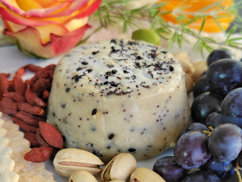 Close up of small cheese wheel on full cheese board