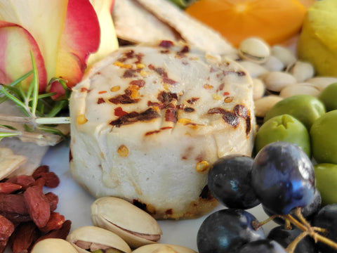 Small cheese wheel on bountiful cheese board