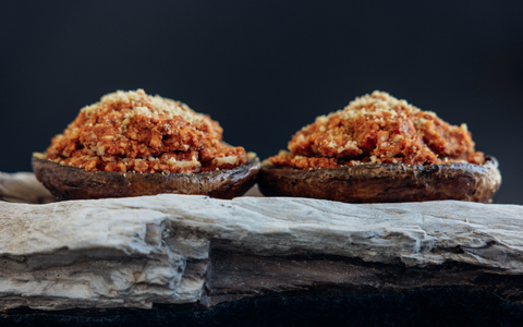 Stuffed portobello mushrooms with walnut parmesan, displayed on a log