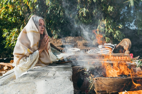 woman in prayer by the fire