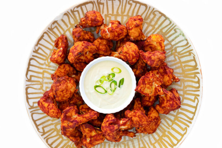 Cauliflower buffalo wings with dip seen from above