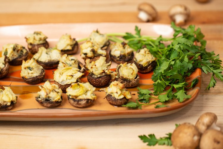 Cheesy sage and artichoke stuffed mushrooms on a large serving platter