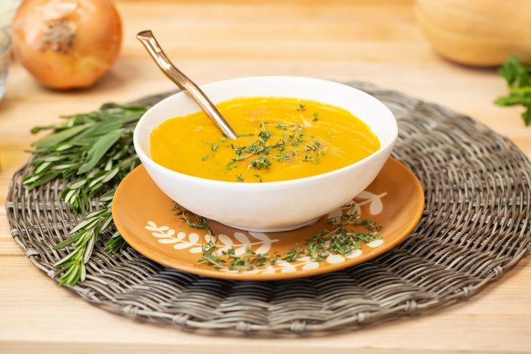 Smoky Butternut Squash Soup in a bowl on a placemat with decorations