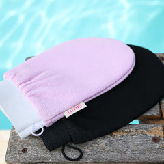 pink and black exfoliating gloves by the pool in summer shot