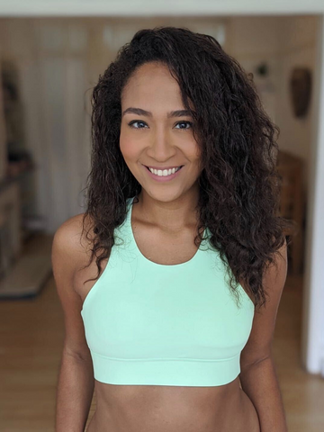 A female spin instructor poses wearing a skimmed milk sports bra