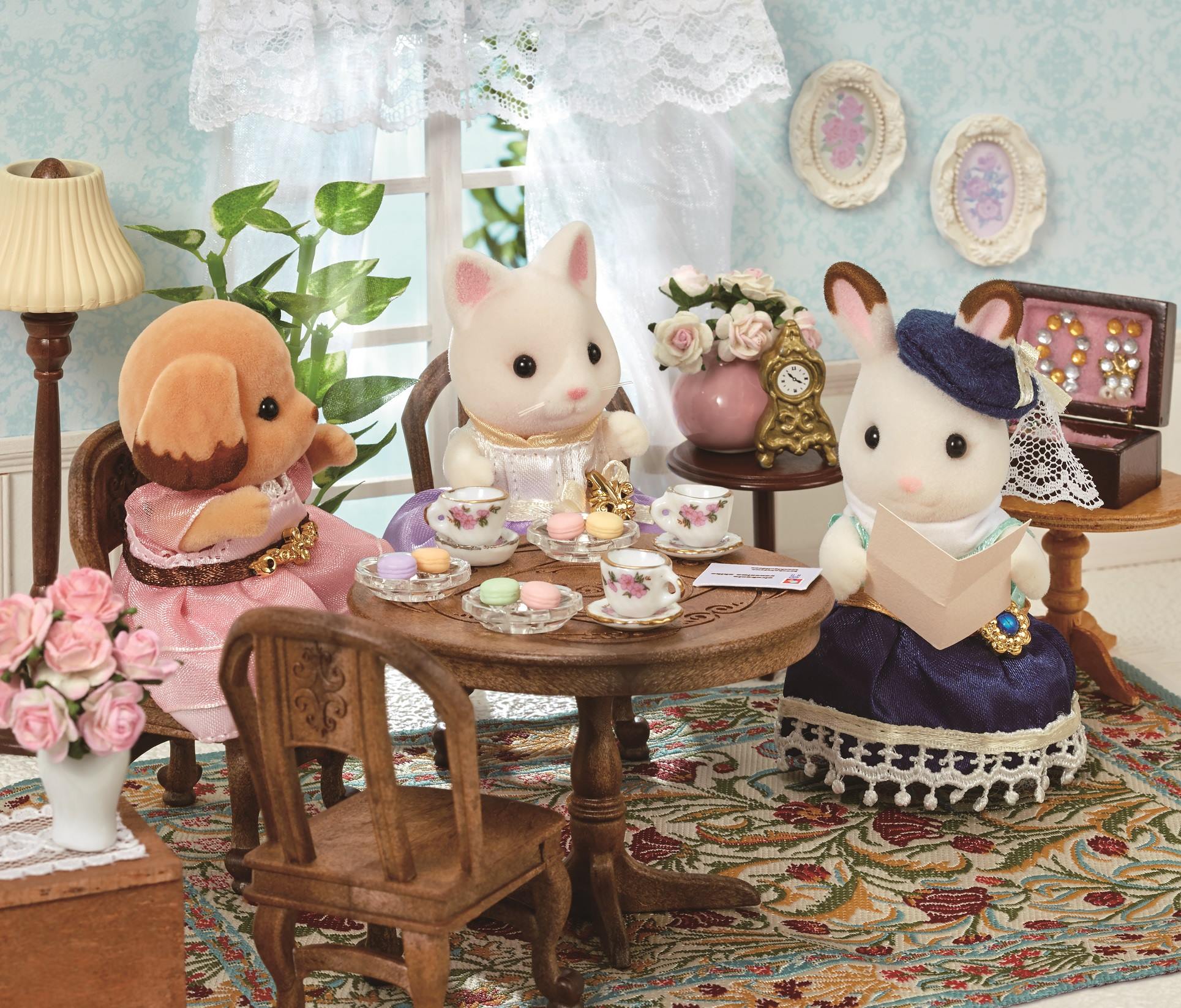 3 Calico Critters dressed as royalties enjoying an afternoon tea.