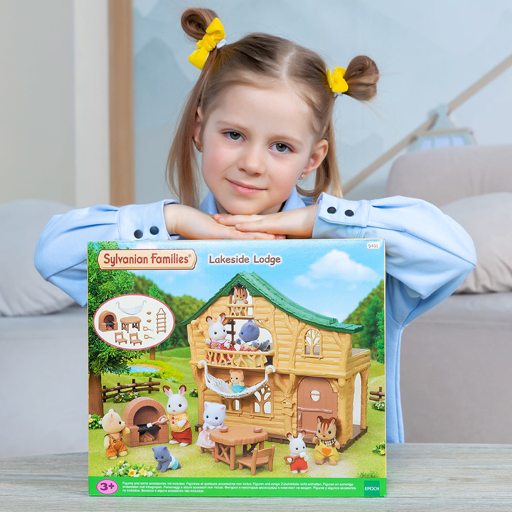 A girl leaning on the packaging of a Sylvanian Families playset