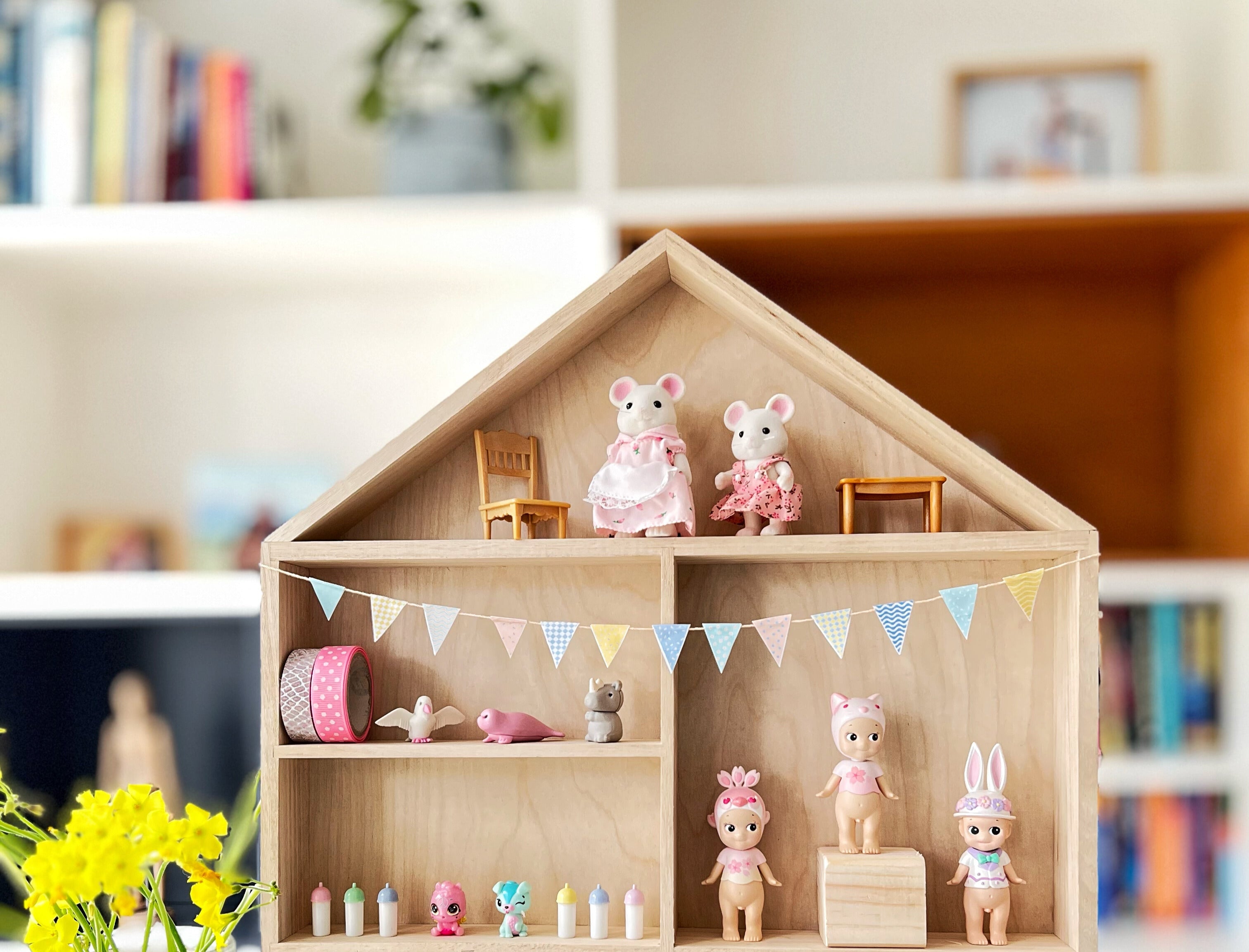 A colorful pastel bunting decorating a house shaped display shelf