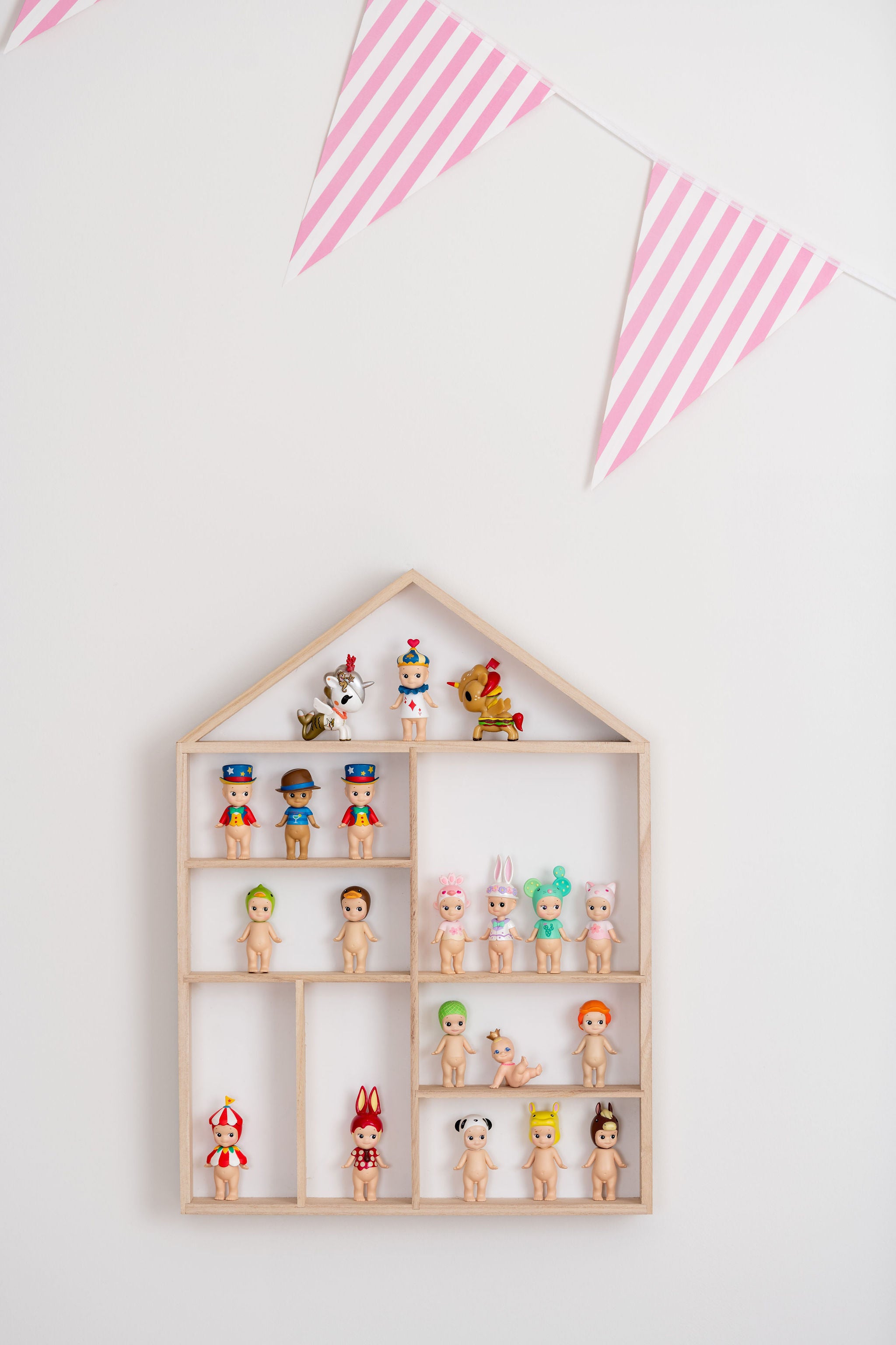 Front view closeup on a house-shaped wooden toy display shelf with Sonny Angels