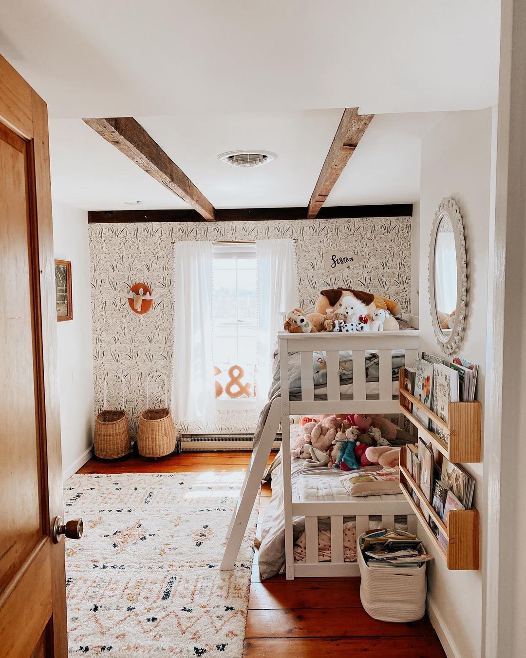 A sisters room with a bunk bed and an accent wall.