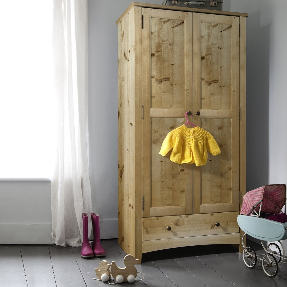 A wooden vintage armoire stands near a window in a kids room
