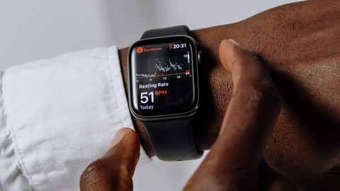 Close-up of a person's wrist with an Apple Watch displaying the resting heart rate