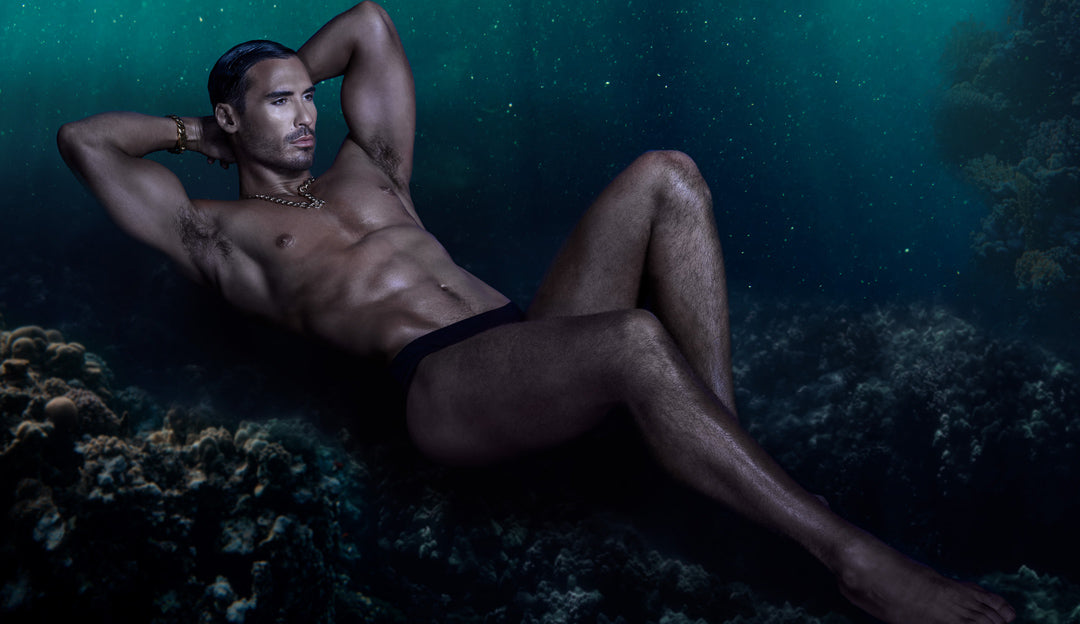 Male model laying in coral reef underwater