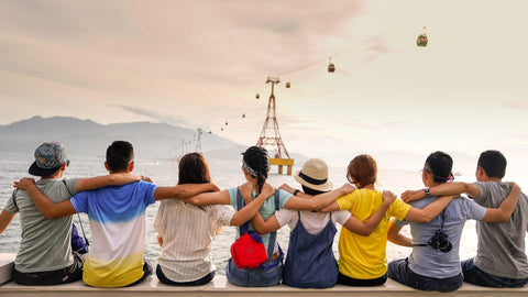 The backs of 8 people with arms across shoulders