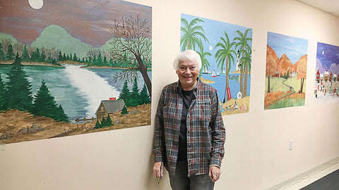Ann with her Four Seasons mural that adorns the wall of the break room at Ann Clark Cookie Cutters.