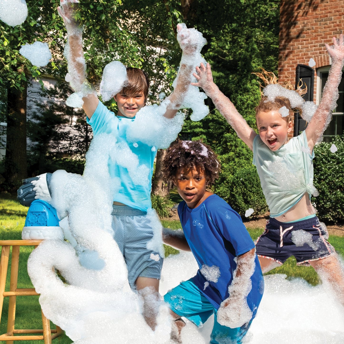 Backyard foam party. Three kids jumping in piles of foam being generated by the Fom Mania Fomalanche foam machine.