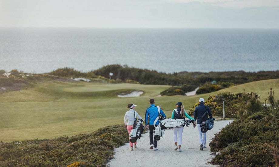 a group of golfers walking through a golf course