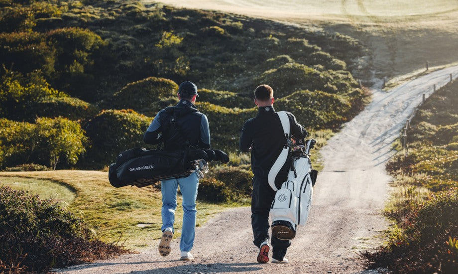 two golfers walk through a golf course