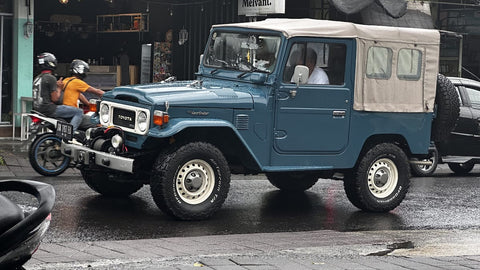 A jeep driving down a street in Bali, Indonesia.