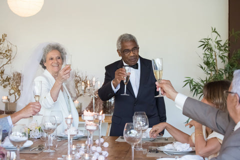 A bride and groom toast at their wedding standing at the sweetheart table