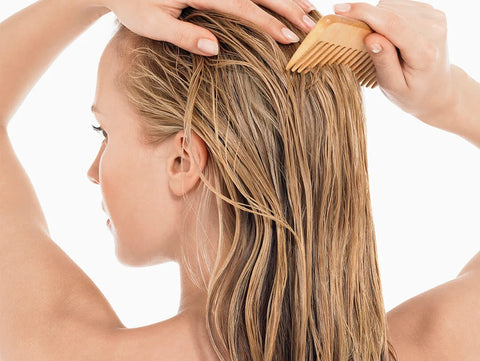 lady combing through her wet hair