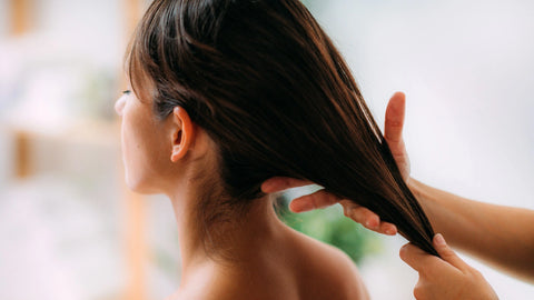 woman combing through another womans hair