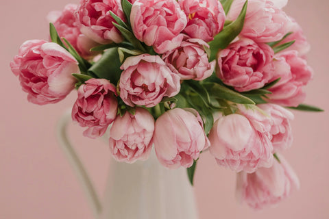 Pink rose bouquet overflowing in white vase