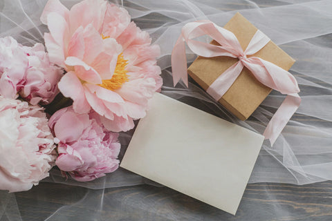 Peony colors - pink peonies next to gift box and envelope