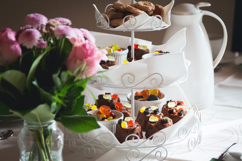 Pink rose bouquet displayed next to tea party snacks