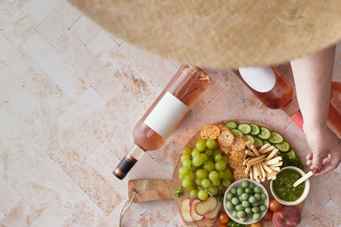 Overhead of charcuterie board with rose wine bottles