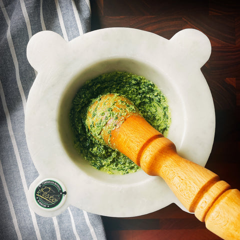A healthy pesto being made in a pestle and mortar