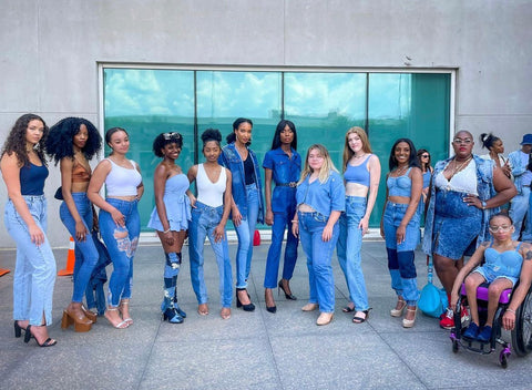 A diverse group of models stand together.