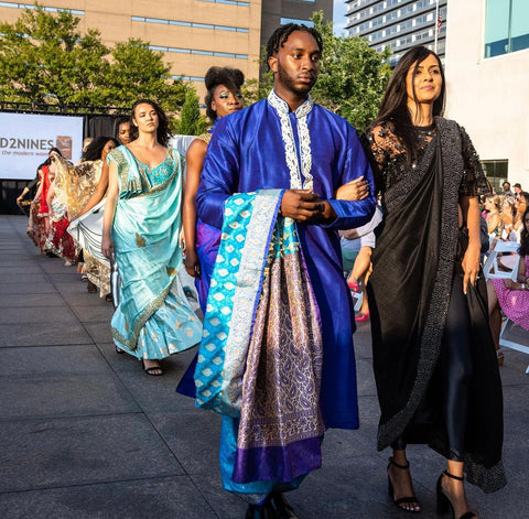 Models walk the runway in colorful, vibrant sarees.