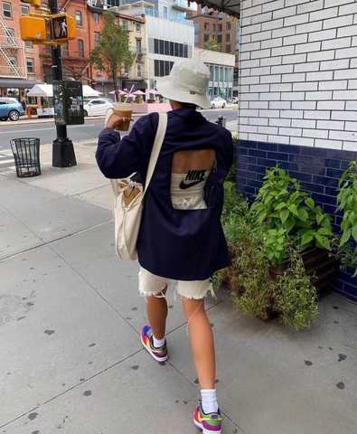 A woman wearing a navy blue blazer with the Nike swoosh symbol on the back