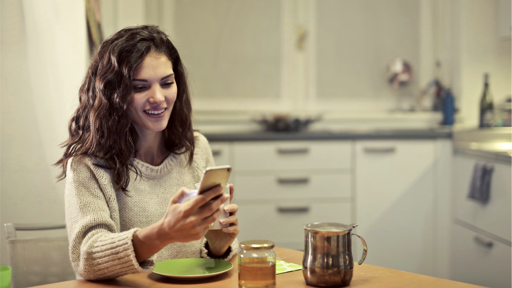 Mujer que usa la aplicación SmartLife en el teléfono móvil para crear automatización