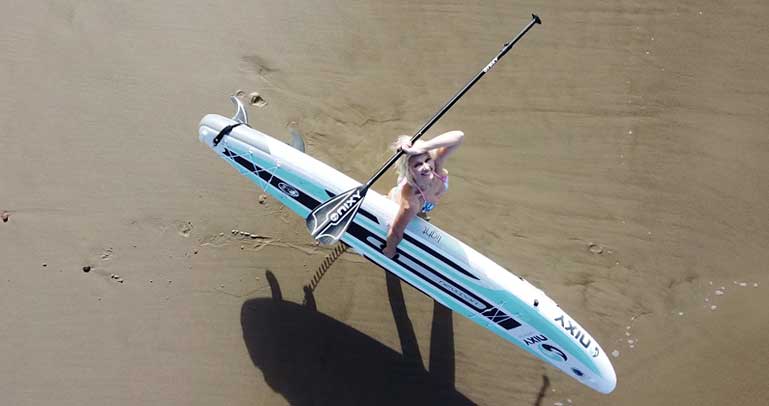 Dominika carrying her Nixty iSUP to the water