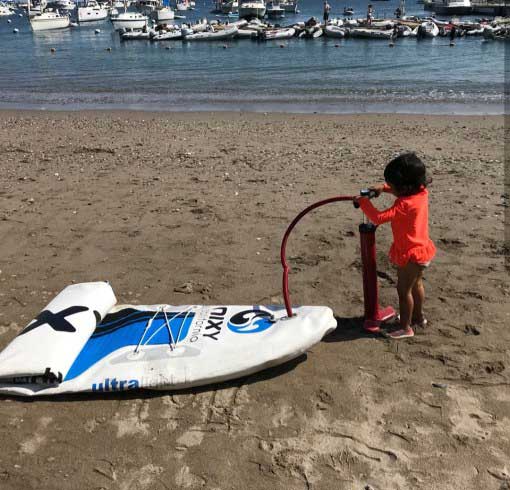 Niño pequeño divirtiéndose mientras bombea Nixy iSUP