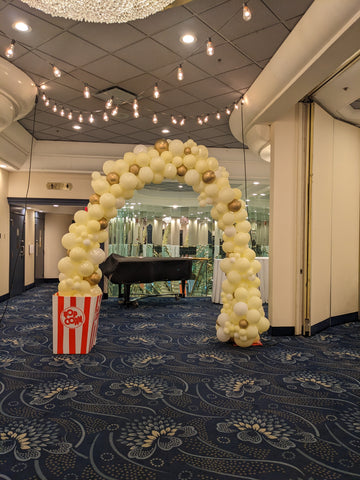 Gold, ivory and white swag arch with popcorn box on one side