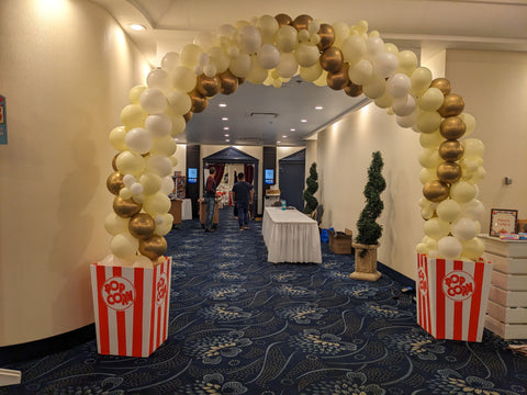Gold, ivory and white spiral arch with popcorn boxes on each side