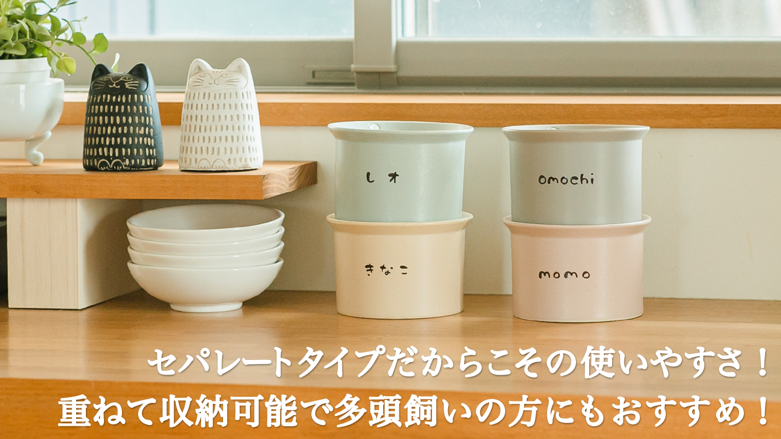 キッチンカウンターに並んだねこ茶碗の画像。左端には黒と白の猫の置物が置かれ、その下には白い積み重ねたねこ茶碗がある。中央には「レオ」と名入れされた水色の台座とその下には「きなこ」と名入れされたベージュの台座、右端には「omochi」と名入れされたグレーのねこ茶碗とその下には「momo」と名入れされたピンクの台座がある。画像の下部には「セパレートタイプだからこその使いやすさ！重ねて収納可能で多頭飼いの方にもおすすめ！」というテキストが添えられている。