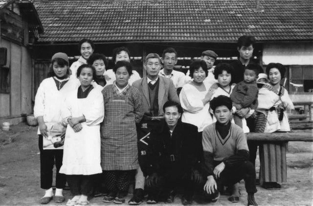 50年前の竹堂園の写真、古い写真のためモノクロ写真で、当時の従業員が集合し並んでいる、背景には昔の工房が映っている
