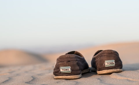 toms shoes on sand