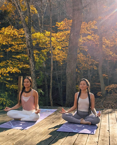 two women in meditation in nature